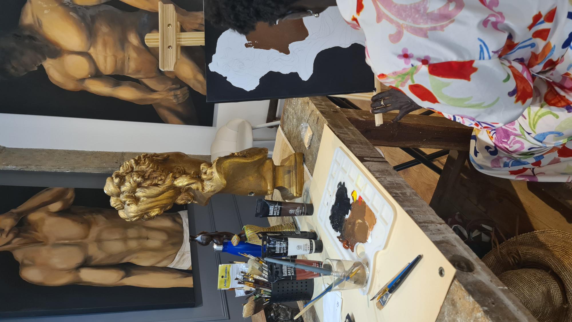 Élève peignant un buste antique à l'acrylique dans l'atelier