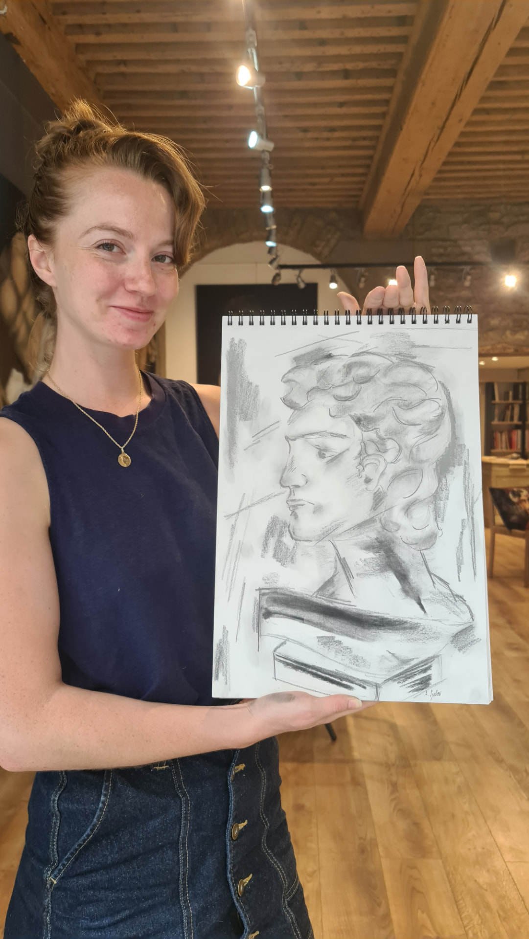 Amandine présentant son dessin au fusain à l'atelier