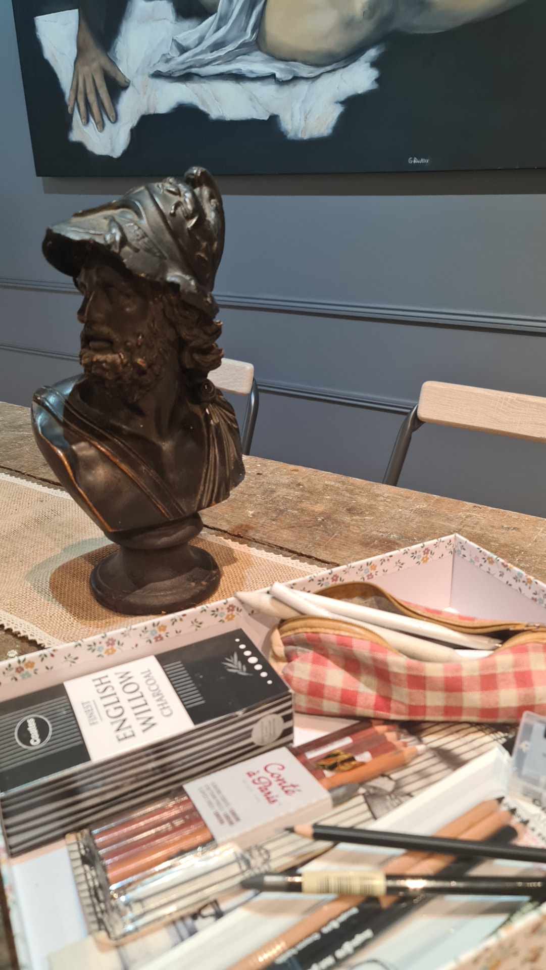 Buste en bronze et matériel de dessin sur l'établi de l'atelier