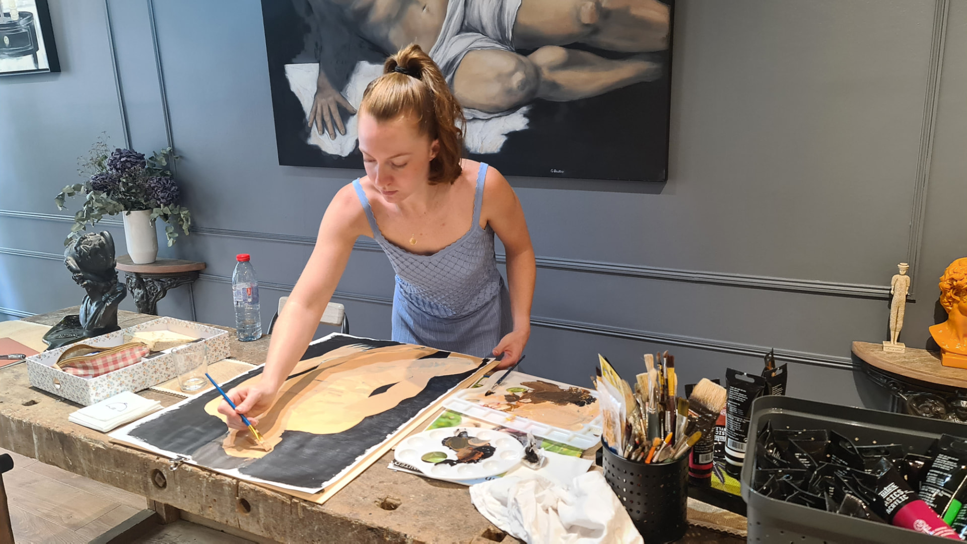 Élève peignant un nu à l'acrylique dans l'atelier